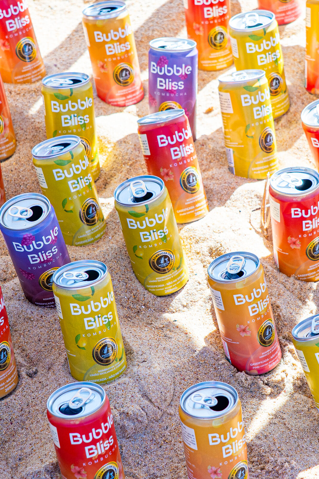 Latas Bubble Bliss espalhadas na areia