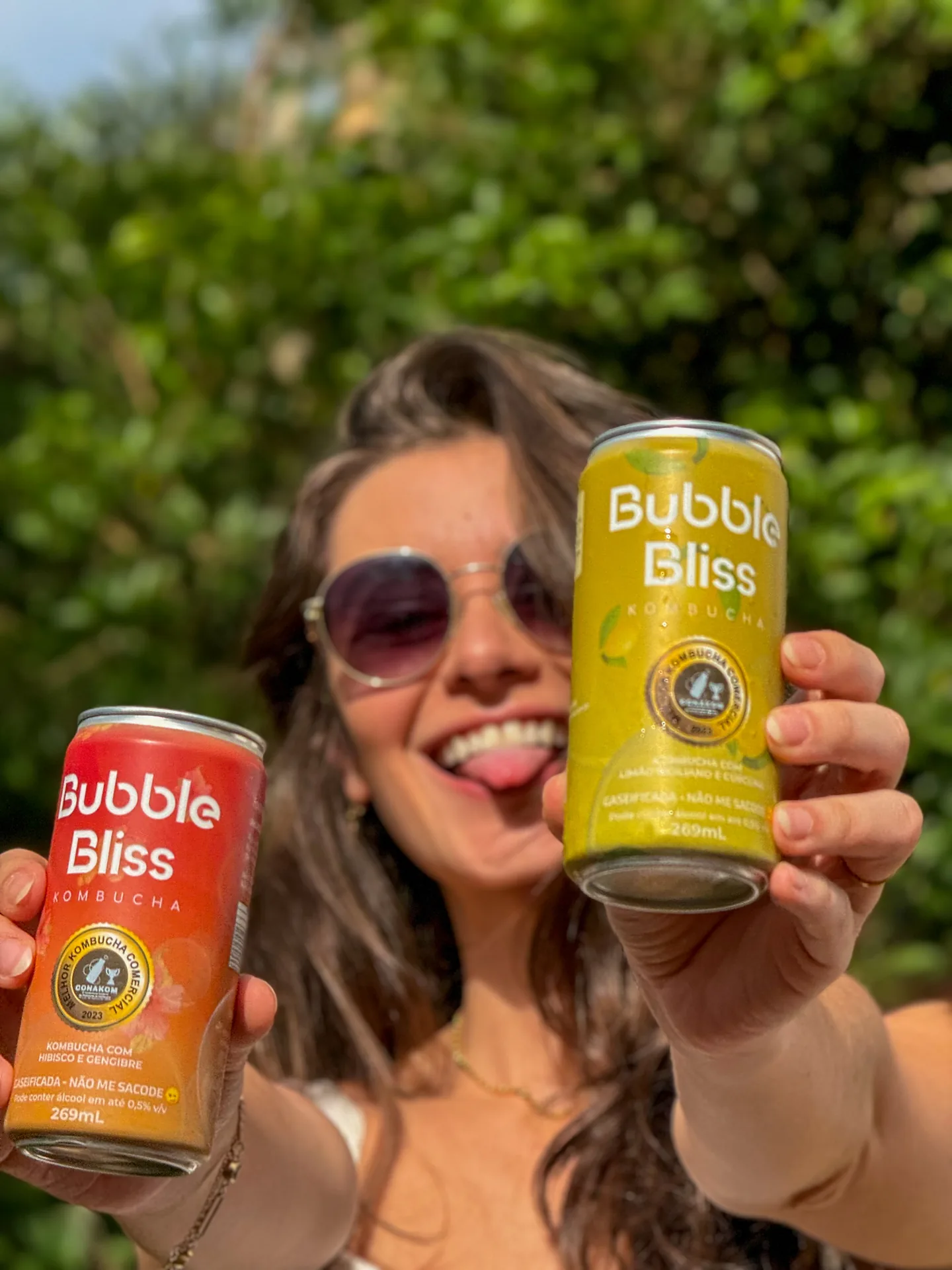 Cliente Bubble Bliss sorrindo segurando duas latas de kombucha